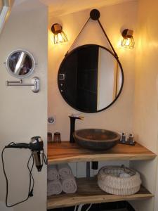Lusignan乐查普罗格酒店的浴室设有水槽和墙上的镜子
