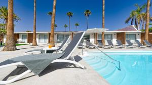 英格兰海滩Sanom Beach Resort Only Adults的一个带躺椅的游泳池,棕榈树