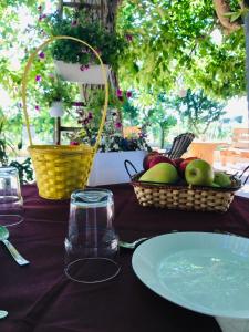 科拉托Tenuta Vigna del Noce的一张桌子,上面放着一盘苹果和一篮水果