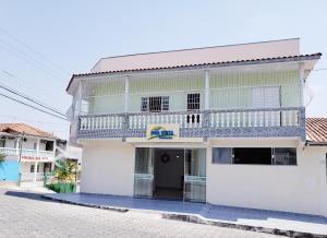 卡舒埃拉保利斯塔Pousada Boa Vista的街道上带阳台的白色建筑