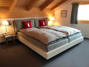 上萨克森Penthouse Apartment - Sez Ner的一间卧室配有一张带红色枕头的大床