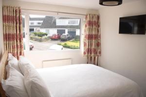 肯德尔Hillgarth Holiday House的一间卧室设有一张床和一个大窗户