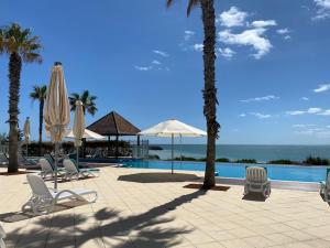 曼哲拉Dolphin View 404的一个带椅子和遮阳伞的度假村和一个游泳池