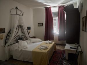 特伦托B&B La Loggia Del Castello的一间卧室设有一张床和一个窗口