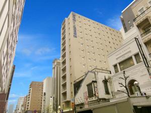 名古屋名铁名古屋锦酒店的一条城市街道上高大的白色建筑