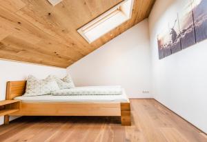 梅劳Haus Moosbrugger的木天花板的客房内的一张床位