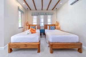 沙美岛Samed Villa Resort的带2扇窗户的客房内的2张单人床