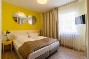 科隆科劳肯伽斯酒店的一间卧室设有一张床和黄色的墙壁