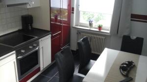 吕格德Ferienbauernhof的带桌椅的厨房以及带炉灶和窗户的厨房。