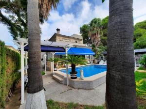 帕尔马海滩Villa Matias Pool and beach的一座带游泳池和棕榈树的房子