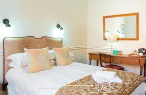 德班玫瑰园旅馆的一间卧室配有一张床和一张带镜子的书桌