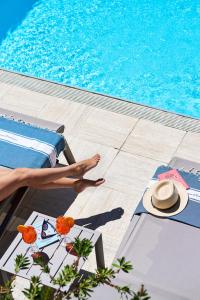 圣马克西姆卡利迪努斯地区酒店的坐在游泳池旁床边的人