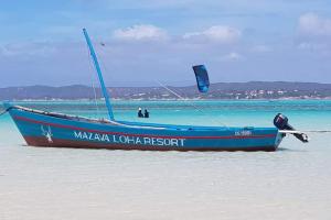 迭戈苏瓦雷斯Mazava Loha Resort的海滩上沙子上的蓝色小船