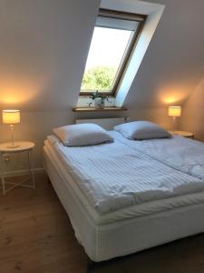 斯坎讷堡Tåning Gl. Mejeri的一间卧室配有一张带窗户和两盏灯的床。