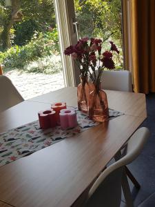 瓦尔韦克B&B de Loeff的一张带鲜花和两根蜡烛的木桌