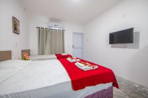 福塔莱萨Luxury Flats Ambiente Cristão的一张白色的大床,上面有红毯