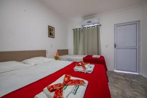福塔莱萨Luxury Flats Ambiente Cristão的一间卧室配有两张红色弓床