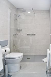 英格兰海滩Sanom Beach Resort Only Adults的一间带卫生间和玻璃淋浴间的浴室