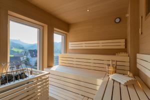 Oberiberg罗格斯图可酒店的一个带长凳和大窗户的桑拿浴室