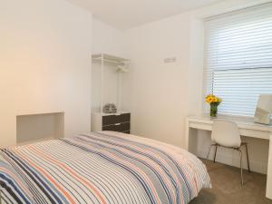 廷茅斯Samphire的一间卧室配有一张床、一张书桌和一个窗户。