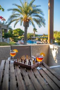 锡蒂亚Sitia Oceanides的木桌上的国际象棋盘和两杯酒杯