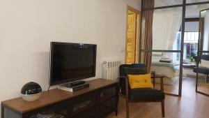 锡古恩萨Murallas de Sigüenza的客厅配有平面电视和椅子。