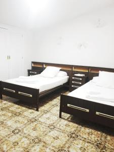 Navas de OroCasa de la Marina的铺有地毯的客房内设有两张床。