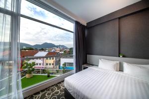 亚依淡Deview Hotel Penang的酒店客房设有一张床和一个大窗户