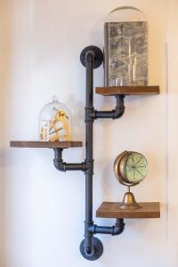考斯Stunning- The Nautilus Bungalow Cowes IOW的墙上挂着时钟的黑管架