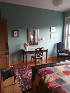 莫法特Kirkview House的一间卧室配有桌子、椅子和镜子