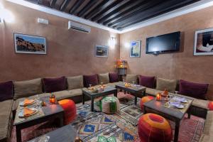 瓦尔扎扎特阿佐尔酒店的客厅配有沙发、桌子和电视