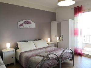 科里利亚诺多特兰托B&B Il Papavero Rosso的一间卧室配有一张带两把椅子的床和一扇窗户