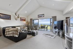 陶波Bay Bliss - Lake Taupo Holiday Home的带沙发和平面电视的客厅
