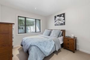 陶波Bay Bliss - Lake Taupo Holiday Home的白色的卧室设有床和窗户