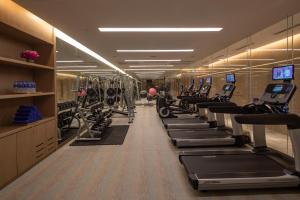 福州福州融侨水乡皇冠假日酒店的健身房,配有一排跑步机和机器