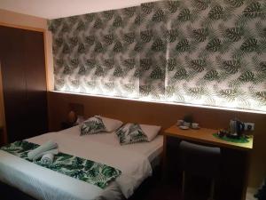 马六甲Grandeur Hotel And Spa的配有床和一张带窗帘的桌子的房间