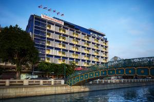 曼谷The Krungkasem Srikrung Hotel的一座建有河上桥梁的酒店大楼