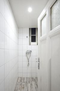 瓦尔纳Hostel Musala的带淋浴和门的白色瓷砖浴室