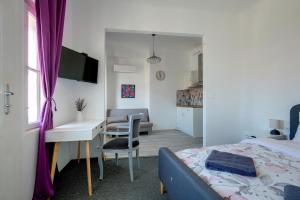 瓦尔纳Hostel Musala的一间带一张床和一张书桌的卧室和一间厨房