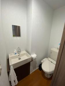 东京Takemura Building 3F的白色的浴室设有水槽和卫生间。