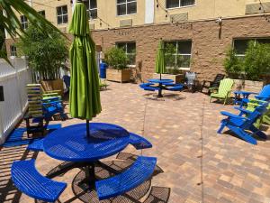 普兰特城Holiday Inn Express & Suites Plant City, an IHG Hotel的天井配有桌椅和绿色雨伞。