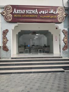 尼兹瓦Aryaf Nizwa Hotel Apartments的一座建筑,设有通往酒店入口的楼梯