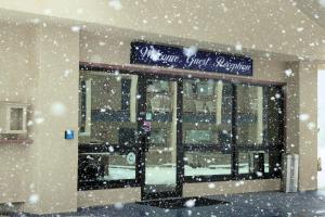 蒙特罗斯Red Arrow Boutique Hotel的一间雪落在前面的商店
