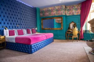 卡迪夫The Coal Exchange Hotel的一间卧室配有一张特大号床和蓝色的墙壁