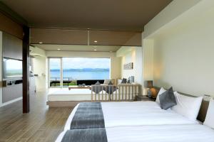 Kohama南群星酒店的一间卧室配有一张床,享有海景