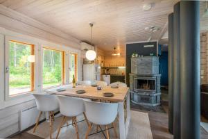 PuolankaLähderinne - Beachfront 2 bedroom log cabin, private beach & sauna的厨房以及带木桌和椅子的用餐室。