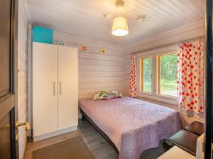 PuolankaLähderinne - Beachfront 2 bedroom log cabin, private beach & sauna的一间小卧室,配有床和窗户