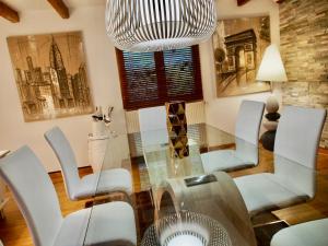 布里德莱班Chalet Greystone的一间设有玻璃桌和白色椅子的用餐室