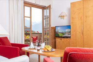 圣沃尔夫冈富力安酒店的客厅配有桌子和电视