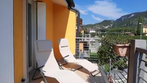 阿科Arco Charme的大楼内的阳台配有白色椅子